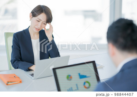 会社で頭を抱える若い女性 98844407