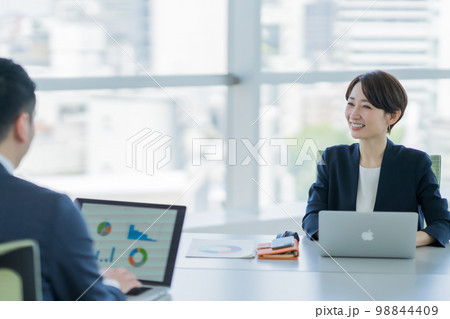 会議で熱心に説明をする若い女性 98844409