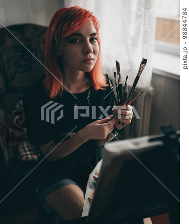 Young redhead woman artist drawing with water colors on canvas 98844784