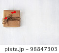 Gift box of craft paper with hearts on the white wooden background. Valentine's Day. 98847303