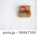 Gift box of craft paper with hearts on the white wooden background. Valentine's Day. 98847309