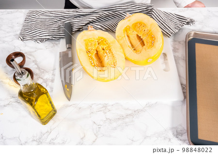 Preparing organic spaghetti squash with olive oil, salt, and pepper. Preparing organic spaghetti squash with olive oil, salt, and pepper. 98848022