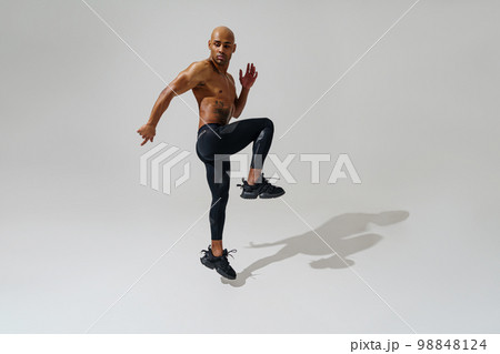 Active sporty man with naked torso jumping on white studio background. Sport and healthy lifestyle 98848124