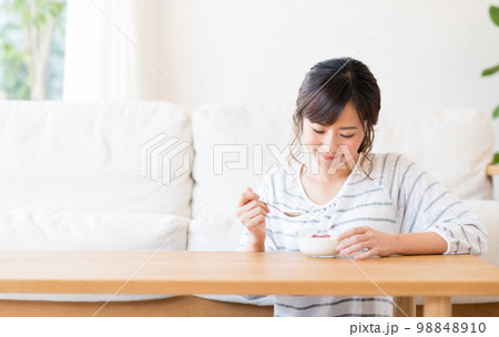 ヨーグルトを食べる若い女性　 98848910