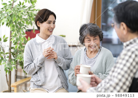 お茶を飲みながら話をする介護士とシニア お茶を飲みながら話をする介護士とシニア 98849113