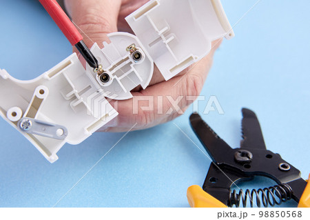 Collapsible electric plug of European standard type f, electrician mounts connector of electric cord. Collapsible electric plug of European standard type f, electrician mounts connector of electric cord. 98850568