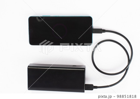 power bank with charging cable and phone, copy space and white background. 98851818