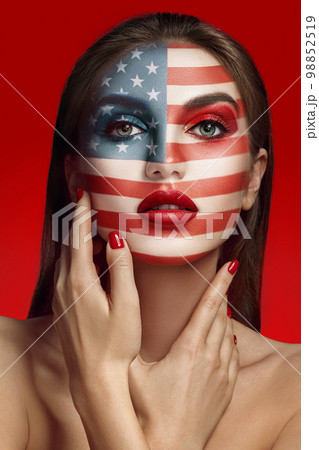 Close-up glamour portrait of a beautiful half-naked model with bright make-up posing over a red background. Close-up glamour portrait of a beautiful half-naked model with bright make-up posing over a red background. 98852519