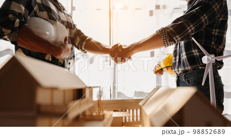 Engineer and contractor join hands after signing contract,They are having a modern building project together. .. 98852689