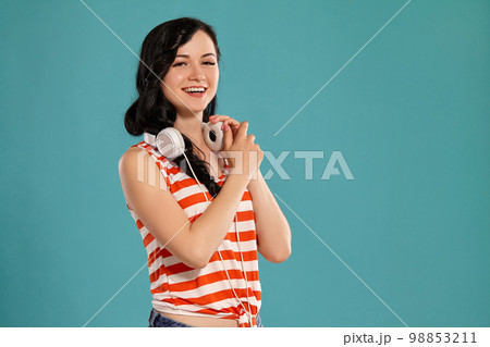 Studio photo of a gorgeous girl teenager posing over a blue background. 98853211