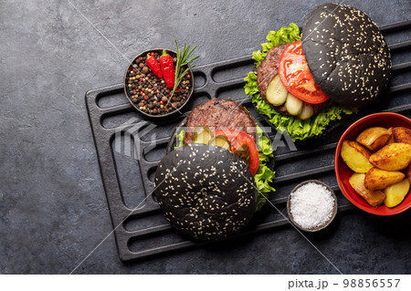 Homemade beef burgers with black buns 98856557