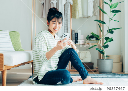 リビングでスマホを見る若い女性 リビングでスマホを見る若い女性 98857467
