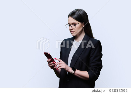 Young business woman using smartphone on white studio background 98858592