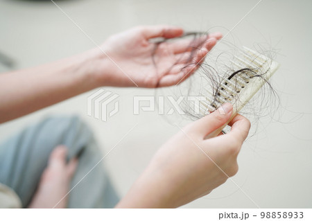 Asian woman have problem with long hair loss attach in her hand. Asian woman have problem with long hair loss attach in her hand. 98858933