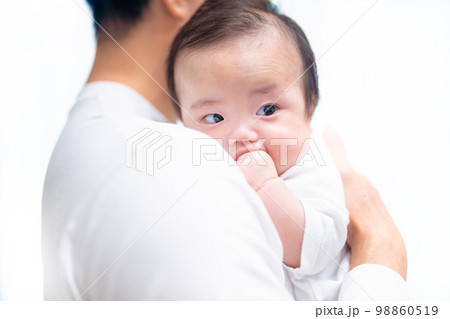 日中にパパに抱っこされて拳しゃぶりをする可愛らしい赤ちゃん 日中にパパに抱っこされて拳しゃぶりをする可愛らしい赤ちゃん 98860519