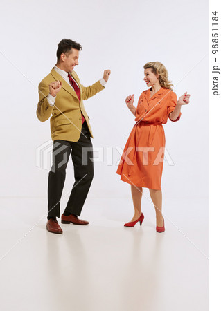 Stylish smiling man and woman in retro style clothes dancing twist dance isolated over white background. Concept of love, relationship, retro style, creativity, family. Stylish smiling man and woman in retro style clothes dancing twist dance isolated over white background. Concept of love, relationship, retro style, creativity, family. 98861184