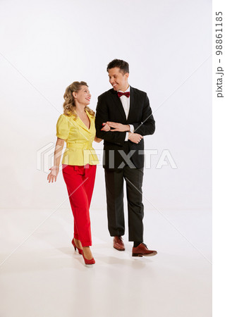 Happy young man and woman, loved couple in retro style clothes walking isolated over white background. Concept of love, relationship, retro style, creativity, family. Happy young man and woman, loved couple in retro style clothes walking isolated over white background. Concept of love, relationship, retro style, creativity, family. 98861185