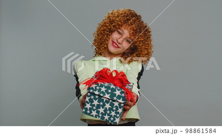Lovely smiling teen child girl kid presenting birthday gift box offer wrapped present celebrating 98861584