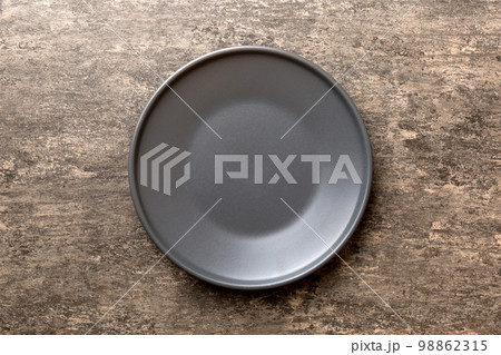 Top view of black plate on cement background. Empty space for your design 98862315