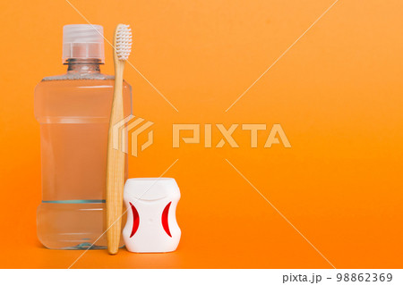 Mouthwash and other oral hygiene products on colored table top view with copy space. Flat lay. Dental hygiene. Oral care products and space for text on light background. concept 98862369