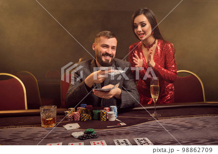 Charming wealthy couple are playing poker at a casino. 98862709