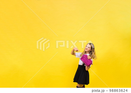 Happy schoolgirl with colored pencils and a pencil case in hand Happy schoolgirl with colored pencils and a pencil case in hand 98863624