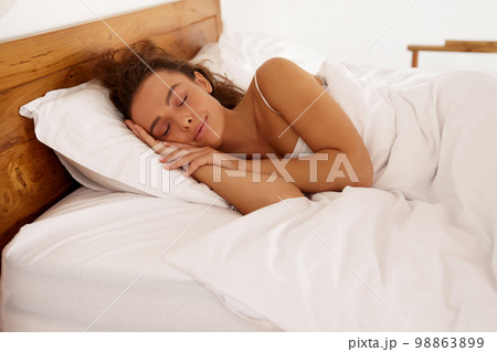 Woman Sleeping at White Bed. Young Girl Laying With Closed Eyes at Cozy Mattress 98863899