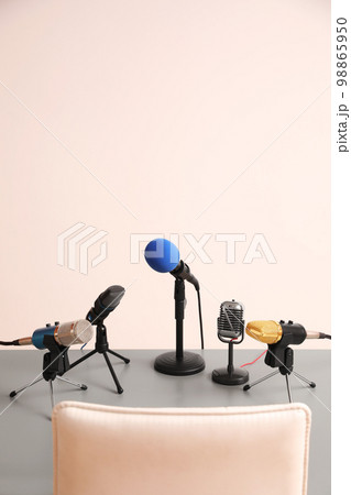Microphones on light grey table in conference hall. Journalist's work 98865950