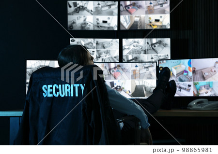 Tired security guard sleeping in office at night 98865981