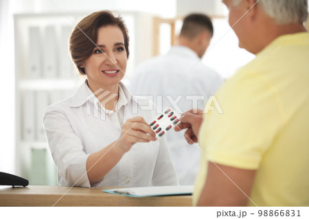 Pharmacist giving medicine to customer in drugstore Pharmacist giving medicine to customer in drugstore 98866831