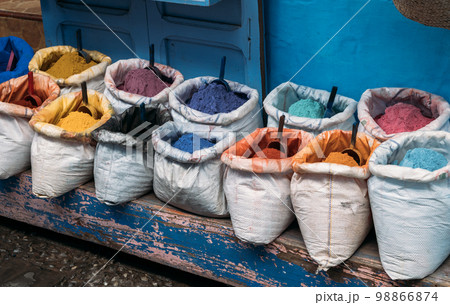 Dry paint for creativity in open bags with bright pigments of different colors are sold at the street market. Street shop in the market in Chefchaouen with colorful powdered dye. 98866874