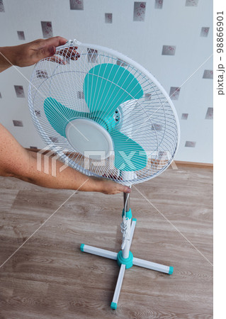Buyer mounts floor fan, which he bought disassembled for self assembly at home from factory parts. 98866901