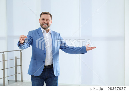 Male real estate agent holding key in new apartment Male real estate agent holding key in new apartment 98867027