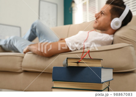 Man with headphones connected to book Man with headphones connected to book 98867083