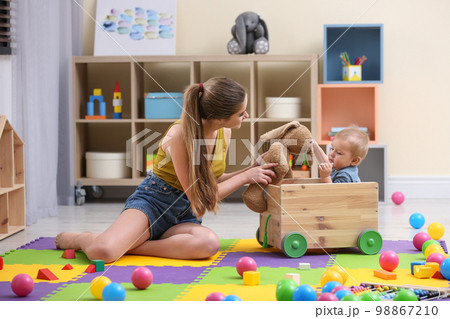 Teen nanny playing with cute little baby at home Teen nanny playing with cute little baby at home 98867210