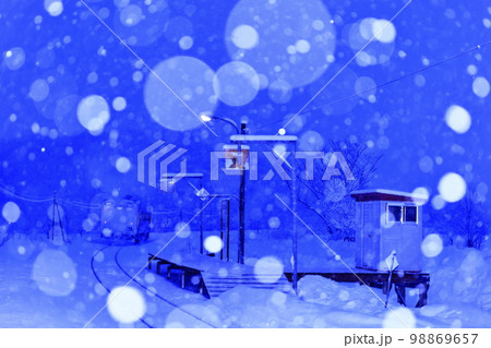 雪降る早朝の宗谷本線糠南駅（走り去る列車を後方から撮影） 98869657