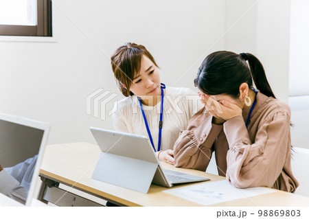 会社のオフィス・会議室で泣くスタッフを慰めるビジネスウーマン（アジア人・日本人・中国人） 98869803