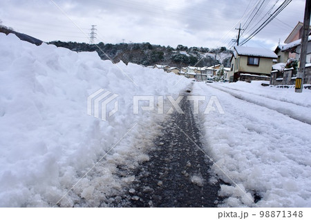 タイヤ跡のついた道路の雪景 98871348