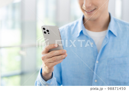 スマホを持つ男性の手元 98871450