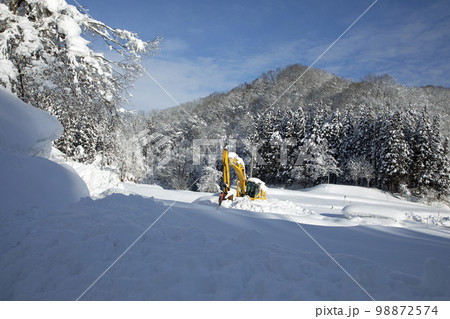 青空に映える雪原と里山、真ん中に除雪車が一台 福島県只見町 青空に映える雪原と里山、真ん中に除雪車が一台 福島県只見町 98872574