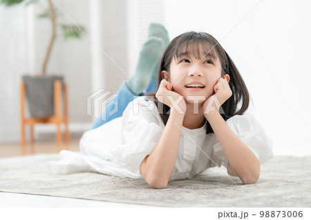 頬杖をついて寝転ぶ女の子 98873006