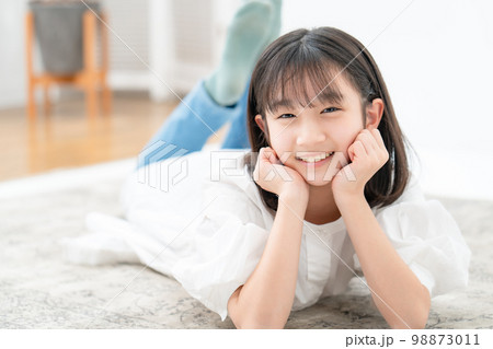 頬杖をついて寝転ぶ女の子 98873011