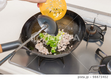 【マーボー茄子を作る 炒め上がったひき肉に青葱を入れる】 【マーボー茄子を作る 炒め上がったひき肉に青葱を入れる】 98873402