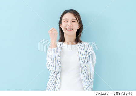 女性　カジュアル　ブルーバック　ガッツポーズ 98873549