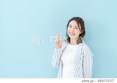 女性　カジュアル　ブルーバック　指差し 98873557