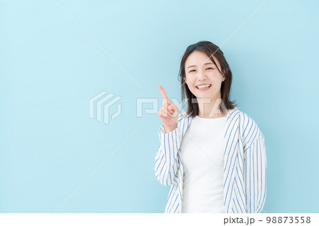 女性　カジュアル　ブルーバック　指差し 98873558