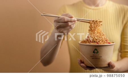 Recycled Packaging Concept. Woman Using Chopsticks to Eating Hot Boiled Instant Noodles from Recycled Bow. Zero Waste Materials. Environment Care, Reuse, Renewable for Sustainable Lifestyle Recycled Packaging Concept. Woman Using Chopsticks to Eating Hot Boiled Instant Noodles from Recycled Bow. Zero Waste Materials. Environment Care, Reuse, Renewable for Sustainable Lifestyle 98875050
