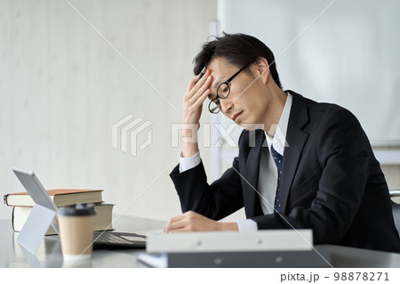 頭を抱えて悩むアジア人ビジネスマン 98878271