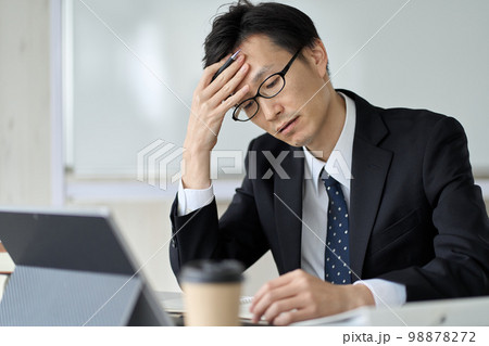 頭を抱えて悩むアジア人ビジネスマン 98878272