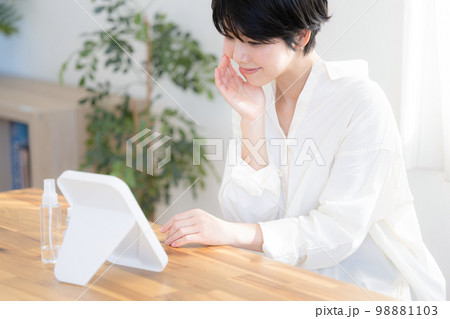 スキンケアで鏡をのぞき込む女性 スキンケアで鏡をのぞき込む女性 98881103